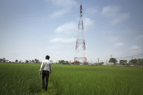 Bik an intern at TAF walks through a rice field outside Vientiane, Laos.