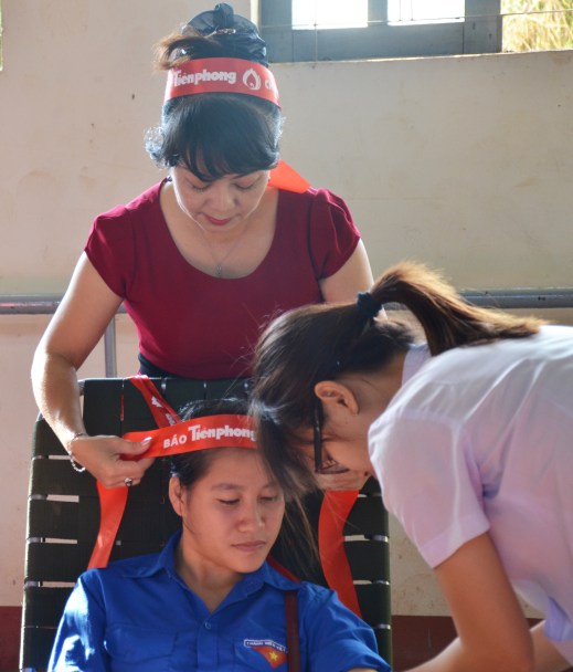 Trưởng tiểu ban tổ chức Chủ Nhật Đỏ tại Đắk Lắk- nhà báo Hoàng Thiên Nga đeo băng cài cho SV hiến máu