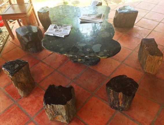 Bộ bàn ghế làm bằng gỗ hóa thạch đặt hờ hững ở góc sân