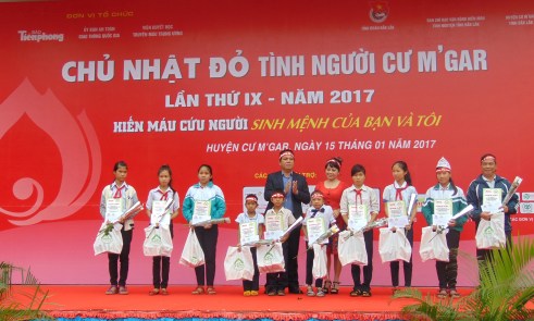 Nhà báo Hoàng Thiên Nga cùng ông Trương Văn Chỉ Chủ tịch UBND huyện Cư Mgar trao học bổng Đọt Chuối Non cho 10 học sinh hiếu học hiếu thảo của huyện