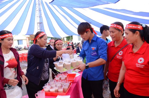 Thanh niên tình nguyện nhận từng khay sữa đi phục vụ người hiến máu
